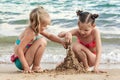 Happy Children Build Sand Castle from Wet Sand on Sea Waves Background Royalty Free Stock Photo