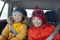 Happy children in the car in the back seat winter trip Royalty Free Stock Photo
