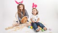 Happy children celebrate Easter. little girls wearing bunny ears enjoying egg hunt. Kids playing with color eggs and flower basket Royalty Free Stock Photo