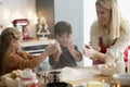 Children clasping using flour while baking cookies