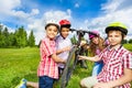 Happy children in colorful helmets repair bicycle Royalty Free Stock Photo