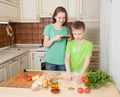 Happy children cooking homemade pizza at home kitchen. Teenager