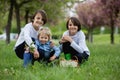 Happy children of different age groups, running together in the park, springtime, having fun