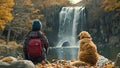 Happy children with dog family sitting by a river with waterfall, enjoying the hike to waterfall summertime on a cold