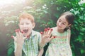 Happy children eating raspberry from fingers in summer garden Royalty Free Stock Photo