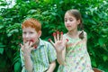 Happy children eating raspberry from fingers in summer garden Royalty Free Stock Photo