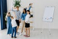 Happy children and educator raising hands up standing in modern classroom. Website header with group portrait of cheerful school Royalty Free Stock Photo