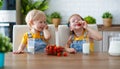 Happy children brother and sister eating strawberries with milk Royalty Free Stock Photo