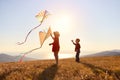 Happy children girl and boy launches a kite at sunset outdoors