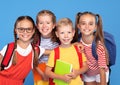 Happy children, girls and boys, standing with backpacks behind and exercise books, smiling at camera Royalty Free Stock Photo