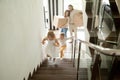 Happy children going upstairs, family with boxes moving in house Royalty Free Stock Photo