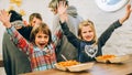 Happy children having fun while eating spaghetti pasta