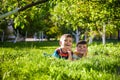 Happy children having fun outdoors. Kids playing in summer park. Little boy and his brother laying on green fresh grass holiday Royalty Free Stock Photo