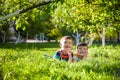 Happy children having fun outdoors. Kids playing in summer park. Little boy and his brother laying on green fresh grass holiday Royalty Free Stock Photo