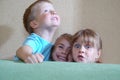 Happy children hiding behind the sofa Royalty Free Stock Photo