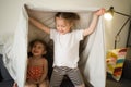 Happy children at home play on sofa bed. Royalty Free Stock Photo