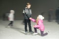 Happy children ice skating at ice rink, winter night Royalty Free Stock Photo