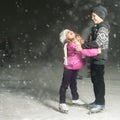 Happy children ice skating at ice rink, winter night Royalty Free Stock Photo