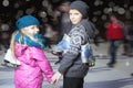 Happy children ice skating at ice rink, winter night Royalty Free Stock Photo