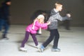 Happy children ice skating at ice rink, winter night Royalty Free Stock Photo