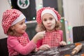 Happy children identical twin sisters tasking biscuits in the kitchen, casual lifestyle photo in real life interior, young family