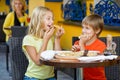 Happy children indoors eating pizza smiling Royalty Free Stock Photo