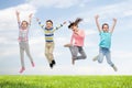 Happy children jumping in air over sky and grass Royalty Free Stock Photo