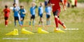 Happy children jumping over sports hurdles on the training pitch. Group of school kids attending sports agility training Royalty Free Stock Photo