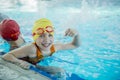 Happy children kids group at swimming pool class learning to swim