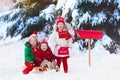 Children with letter to Santa at Christmas mail box in snow Royalty Free Stock Photo