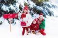 Children with letter to Santa at Christmas mail box in snow Royalty Free Stock Photo