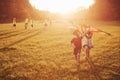 Happy children launch a kite in the field at sunset. Little boy and girl on summer vacation Royalty Free Stock Photo