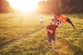 Happy children launch a kite in the field at sunset. Little boy and girl on summer vacation Royalty Free Stock Photo