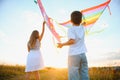 Happy children launch a kite in the field at sunset. Little boy and girl on summer vacation. Royalty Free Stock Photo