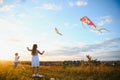 Happy children launch a kite in the field at sunset. Little boy and girl on summer vacation. Royalty Free Stock Photo
