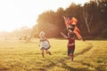 Happy children launch a kite in the field at sunset. Little boy and girl on summer vacation Royalty Free Stock Photo