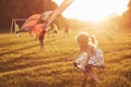 Happy children launch a kite in the field at sunset. Little boy and girl on summer vacation Royalty Free Stock Photo