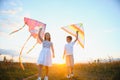 Happy children launch a kite in the field at sunset. Little boy and girl on summer vacation. Royalty Free Stock Photo