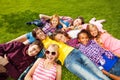 Happy children laying together on green grass