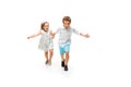 Happy children, little caucasian boy and girl jumping and running isolated on white background Royalty Free Stock Photo