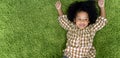 Happy children little girl smiling and laying on green carpet floor in living room at home. Royalty Free Stock Photo