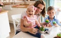 Happy children with mother eating cupcakes Royalty Free Stock Photo