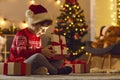 Cheerful boy feeling happy after opening festive gift box with Christmas presents inside Royalty Free Stock Photo