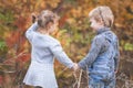 Happy children outdoor at fall season, holding hands. Has date