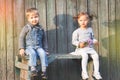 Happy children outdoor at fall season, sitting bench. First date Royalty Free Stock Photo