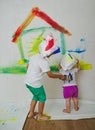 Happy children painting wall at home Royalty Free Stock Photo