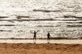 Happy children playing at the beach at sunset