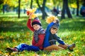 Happy children playing in beautiful autumn park on warm sunny fall day. Kids play with golden maple leaves Royalty Free Stock Photo