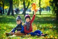 Happy children playing in beautiful autumn park on warm sunny fall day. Kids play with golden maple leaves Royalty Free Stock Photo