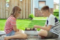 Happy children playing chess on backyard at sunny day while summer holidays Royalty Free Stock Photo